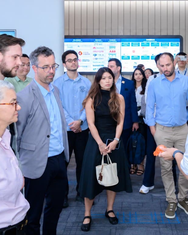 Grupo de executivos acompanha uma demonstração de produto durante visita empresarial na China
