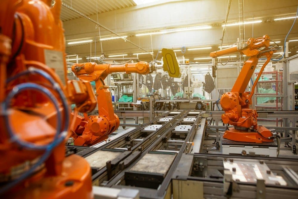 Braços robóticos em uma linha de produção industrial
